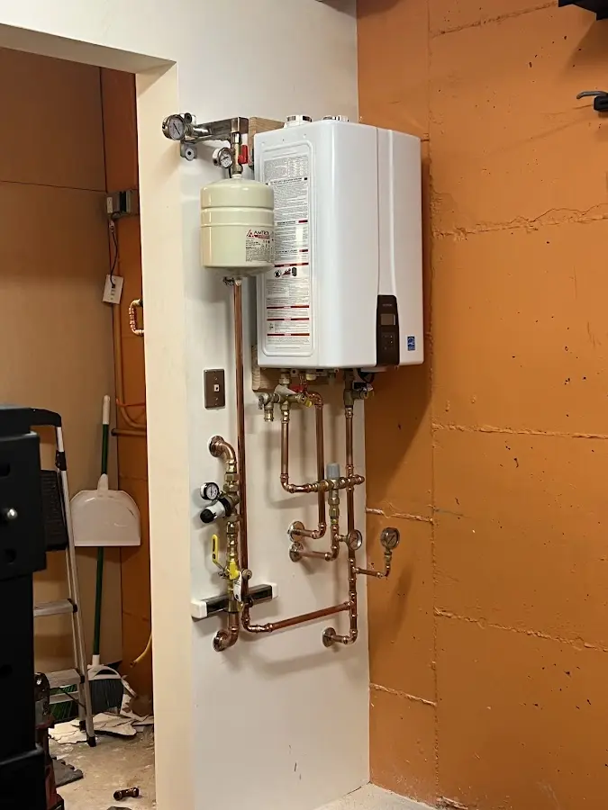 Plumbing technician inspecting water heater connections in Meridianville